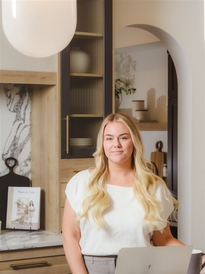 Amy Williams working on her laptop in a bright kitchen