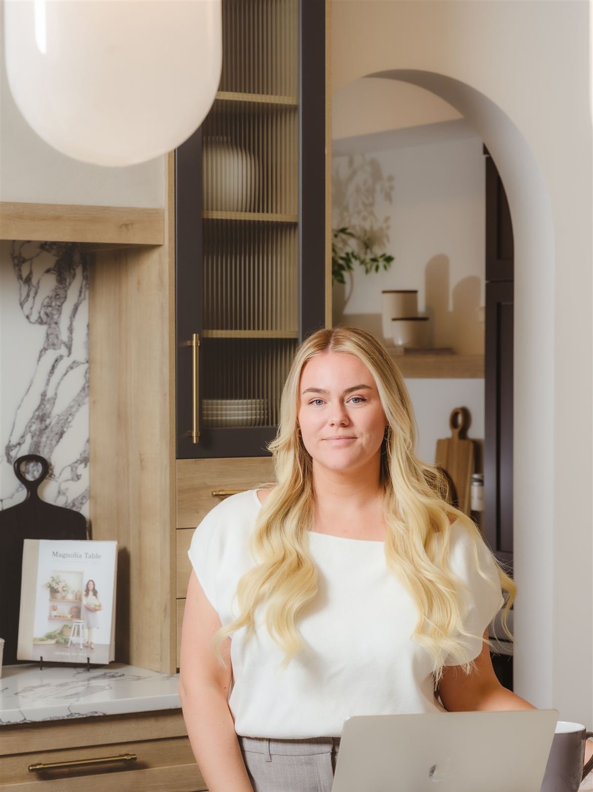 Amy Williams standing at a marble kitchen island with her laptop