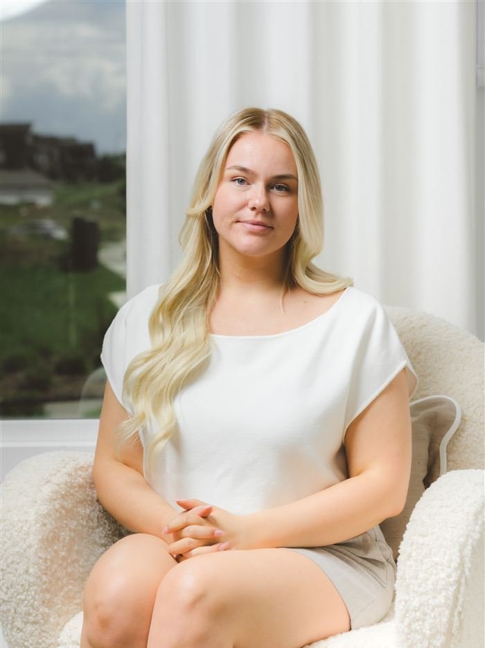 Portrait of Amy Williams seated in a cream armchair